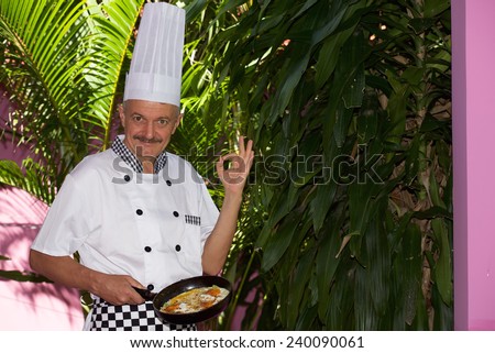 Chief cook with scrambled eggs in frying pan