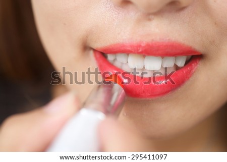 Pretty asian girl male up lipstick her lips