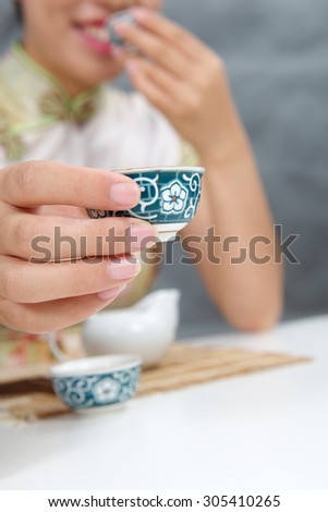 Chinese girl holding cup of tea and offer taste it