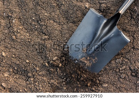 black earth texture with a black metal shovel - stock photo