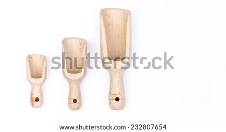 Three wooden scoops one small, one medium and one large used as dosage, isolated on white background