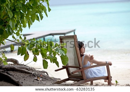 asian girl sitting in the chair on maldives beach