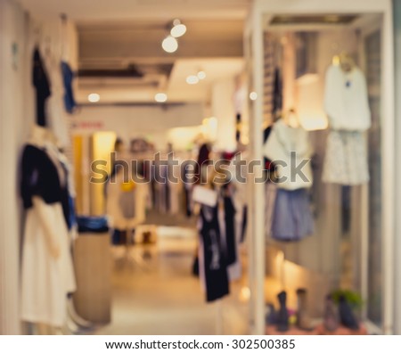 De focused/Blur image of boutique window with dressed mannequins. Boutique display window with mannequins in fashionable dresses