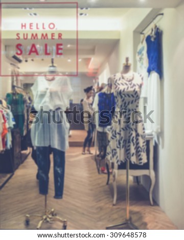 De focused/Blur image of boutique window with dressed mannequins. Boutique display window with mannequins in fashionable dresses.