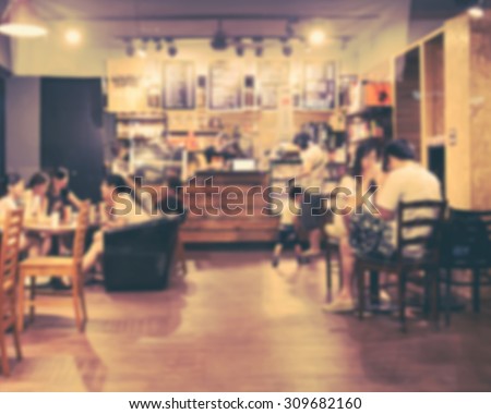 De focused/Blurred image of people sitting in cafe chatting, using cell phone and buying coffee. Retro effect.