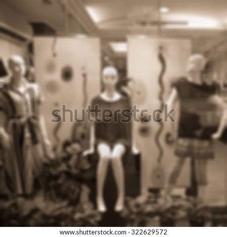 Boutique window with dressed mannequins. Boutique display window with mannequins in fashionable dresses. Sepia tone.