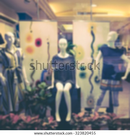 Boutique window with dressed mannequins. Boutique display window with mannequins in fashionable dresses. Retro effect.