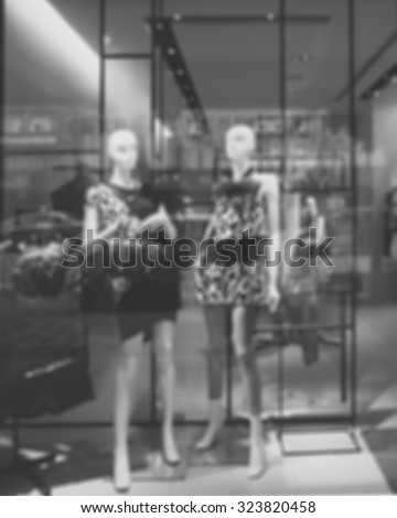De focused/Blur, black and white image of boutique window with dressed mannequins. Boutique display window with mannequins in fashionable dresses.