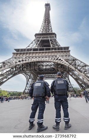 PARIS, FRANCE - APRIL 26, 2015 : French policemen in front of Eiffel tower (Tour Eiffel) because of plan Vigipirate, plan against attack terrorist