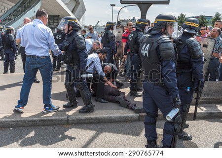 PARIS, FRANCE - JUNE  25, 2015 :  A man on a floor because of tear gas from french police (riot squad) is rescued by taxi drivers at Porte Maillot.