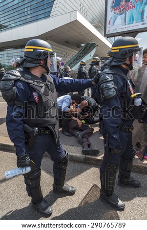 PARIS, FRANCE - JUNE  25, 2015 :  A man on a floor because of tear gas from french police (riot squad) is rescued by taxi drivers at Porte Maillot.