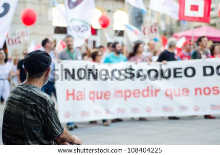 PONTEVEDRA - JULY 19: A man watches the passing of the demonstration in protest at cuts to staff members, by the current government in Spain, on July 19, 2012 in Pontevedra, Spain.