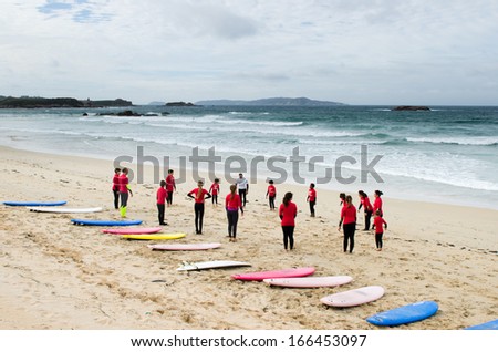PONTEVEDRA, OCTOBER 27: Youth belonging to a surf school warm-up exercise before surfing the waves on the beach A Lanzada in Galicia (Spain) during the fall, October 27, 2013.