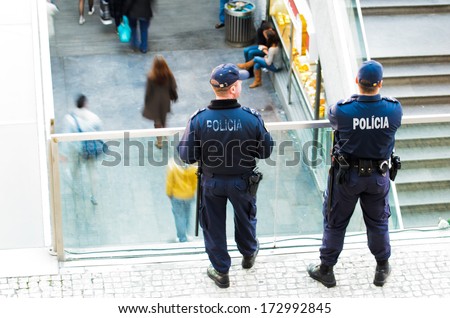 LISBON, PORTUGAL - DECEMBER 5, 2013: Two national police watching from a balcony the main entrance to the Oriente Railway Station in Lisbon.