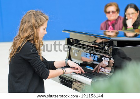 BILBAO, SPAIN - APRIL 4, 2014: A girl plays a grand piano during music initiative \