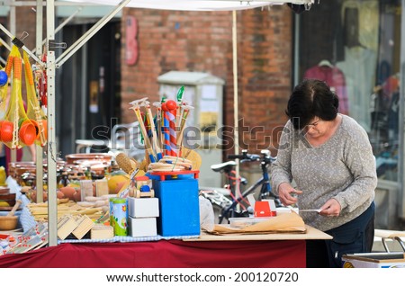 BARCELONA, SPAIN - APRIL 11, 2014: A woman attends a job selling toys at a street stall.
