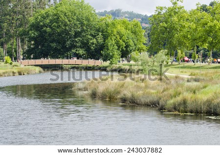 PONTEVEDRA, SPAIN - AUGUST 3, 2014: Many people walk through one of the wooden bridges, in one of city parks.