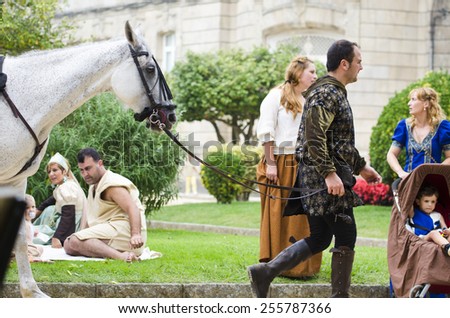 PONTEVEDRA, SPAIN - SEPTEMBER 6, 2014: A man with medieval clothing, walking with a horse in medieval festival held each year in the historical district of the city.