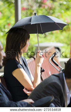 TOULOUSE, FRANCE - OCTOBER 4, 2014: A woman with a tiny umbrella protects from the sun.