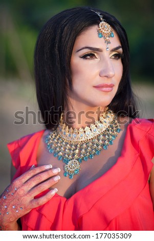 Beautiful Indian Woman in a Sari Smiling and dancing Outdoors. Woman greeting in mekhla. Girl bollywood dancer. Indian Bride with traditional makeup and jewelry. Series.