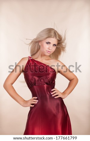 Portrait of beautiful blonde woman in red dress fashion studio, sexy young girl in red dress. Elegant romantic woman in long red dress. Summer fashion.