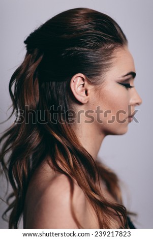 Side portrait of attractive young woman in studio with eyes closed