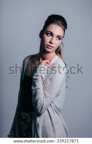 Studio Portrait of Young Attractive Woman sweater on looking away from camera hand on shoulder