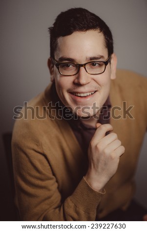 cheesy and silly 1950-1970 portrait of young adult man with hand below chin smiling