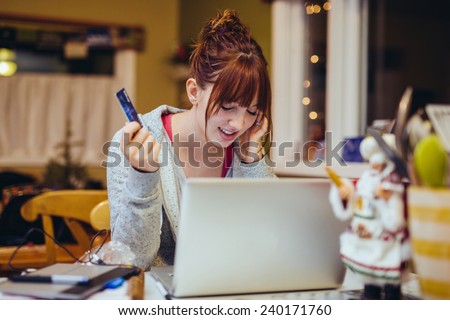 Young Woman at Computer stressed with a credit card disbelief eyes closed