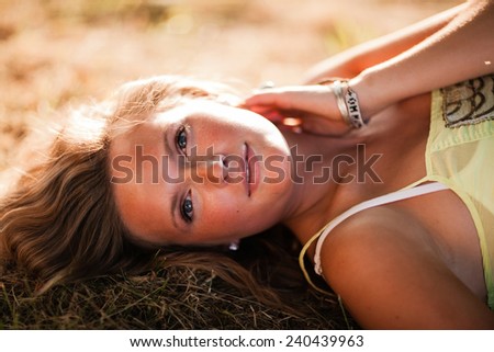 Beautiful Blonde Young Woman laying down in shade glowing skin variation hand on neck