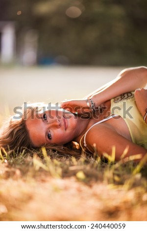 Beautiful Blonde Young Woman laying down in shade glowing skin variation hand on neck