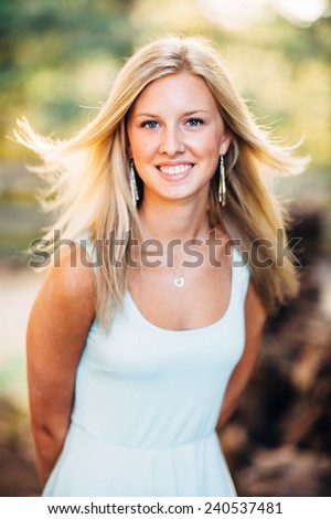 portrait of beautiful young blonde woman hair blowing in wind
