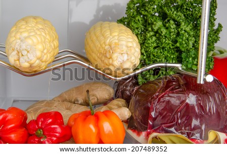 Part of a refrigerator full of different vegetables