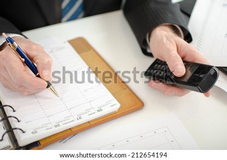 Businessman using a phone for take an appointment in his diary