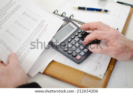 Businessman calculating financial results at his desk