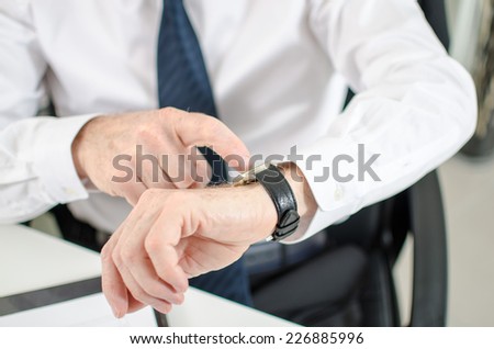 Businessman looking at his watch at office