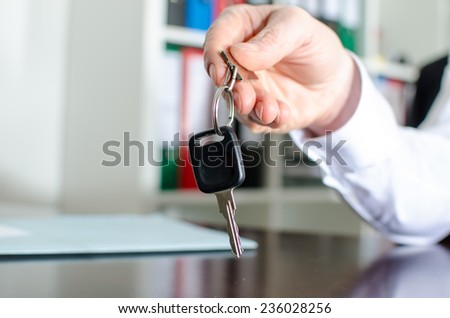 Salesman holding car key in his hand