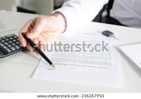 Car salesman showing a sales contract at office