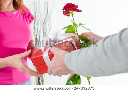 Man giving a rose and a gift to a woman for Valentine\'s day