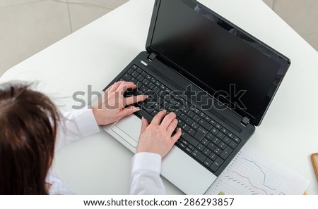 Businesswoman typing on a laptop, top view