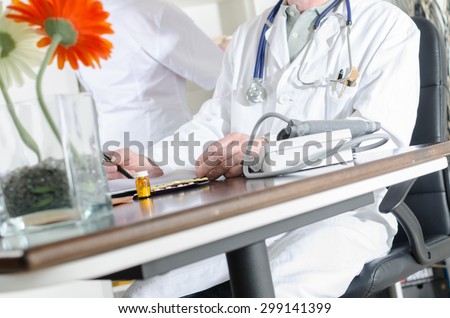 Doctor reading notes at his desk in medical office