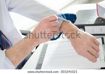 Businessman rolling up his sleeve at office
