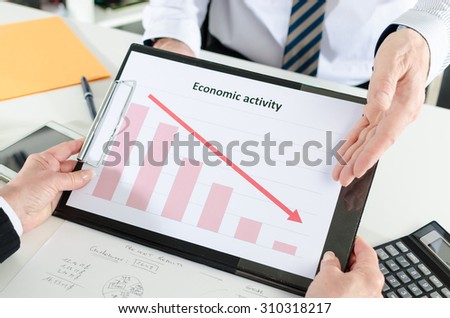 Businessman showing graph falling down