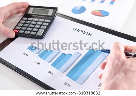 Businessman analyzing financial results with calculator