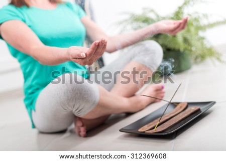 Woman doing yoga in an incense atmosphere