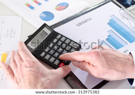 Businessman analyzing financial results with calculator