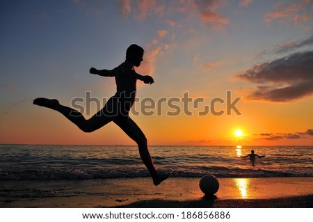 Two Guys playing at the ball on the coast of the sea in sunset