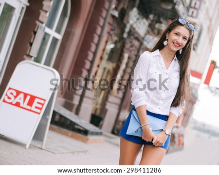 Young woman in the city over streets of shops