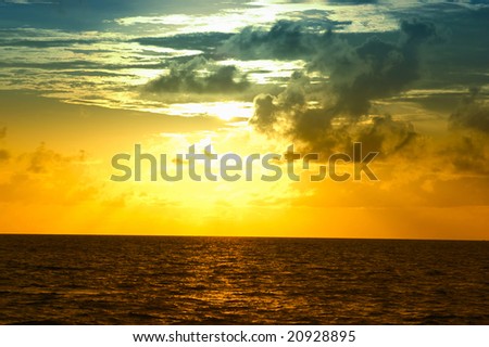 Golden sunlight through clouds on the sea