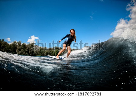 Image, Stock Photo Surfer woman with wetsuit and surfboard looking at the sea